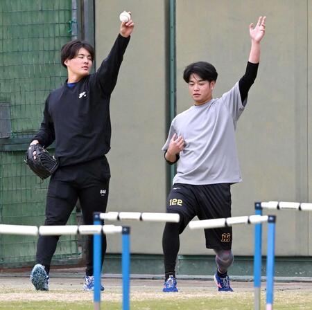 　契約更改前には鳴尾浜でトレーニングし、前川（左）にスローイングのアドバイスを送る高橋（撮影・北村雅宏）