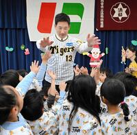 　別れ際、園児とハイタッチであいさつする岩崎（撮影・金居みつよし）