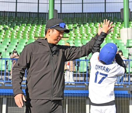 　ドジャース・大谷翔平のユニホームを着用した子どもとタッチを交わす藤川監督（撮影・中田匡峻）