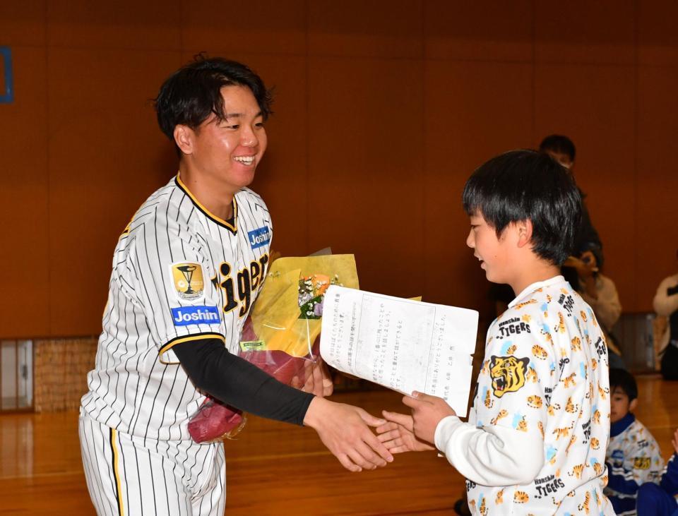 　子どもと笑顔で握手を交わす村上（撮影・中田匡峻）