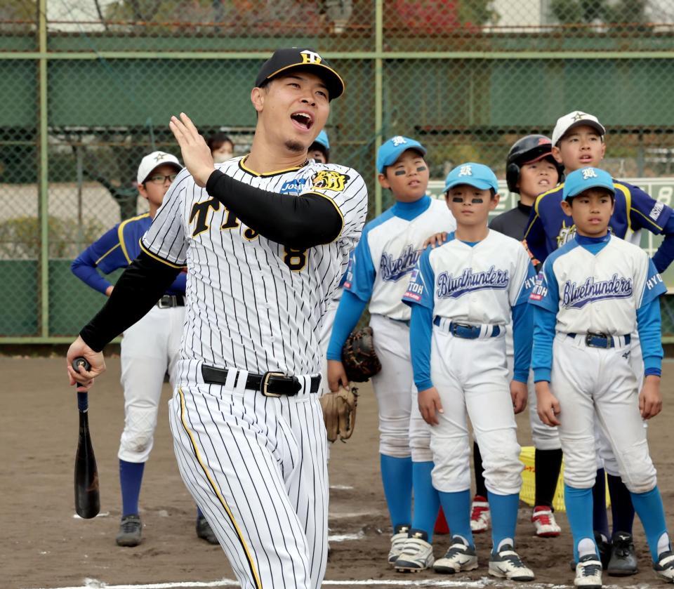 　子供たちの前で打撃のお手本を見せ、フルスイングする佐藤輝（撮影・田中太一）