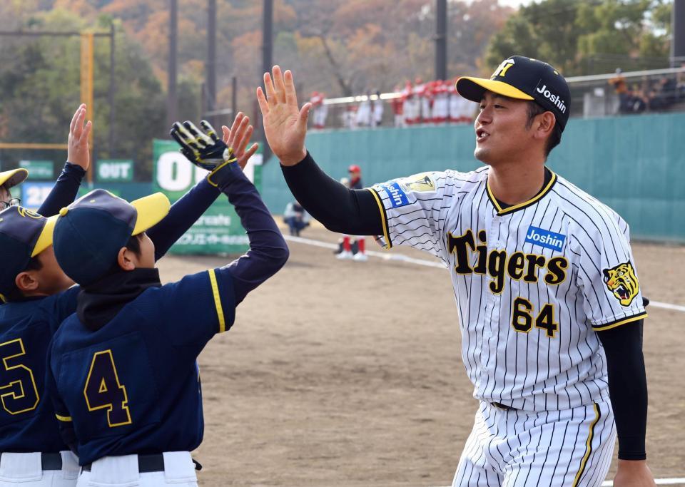 　子どもたちと野球盤を楽しむ岡留（撮影・山口登）