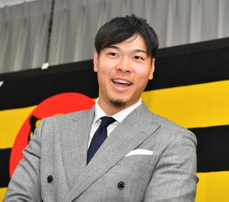 　契約更改を終え、囲み取材で笑顔を見せる佐藤輝（撮影・中田匡峻）