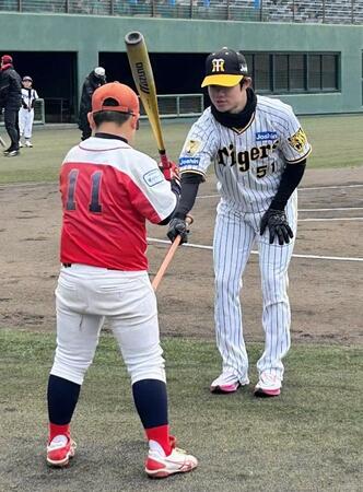 　子どもに打撃指導をする中野