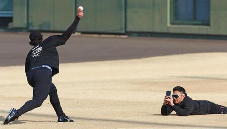 　投球練習する佐藤蓮（左）をスマートフォンで撮影する藤田（撮影・立川洋一郎）
