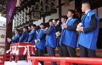 　初天神梅花祭に参加し、福玉を投げる（右から）福島、松原、津田、石黒、百崎、山田、椎葉、下村（撮影・立川洋一郎）