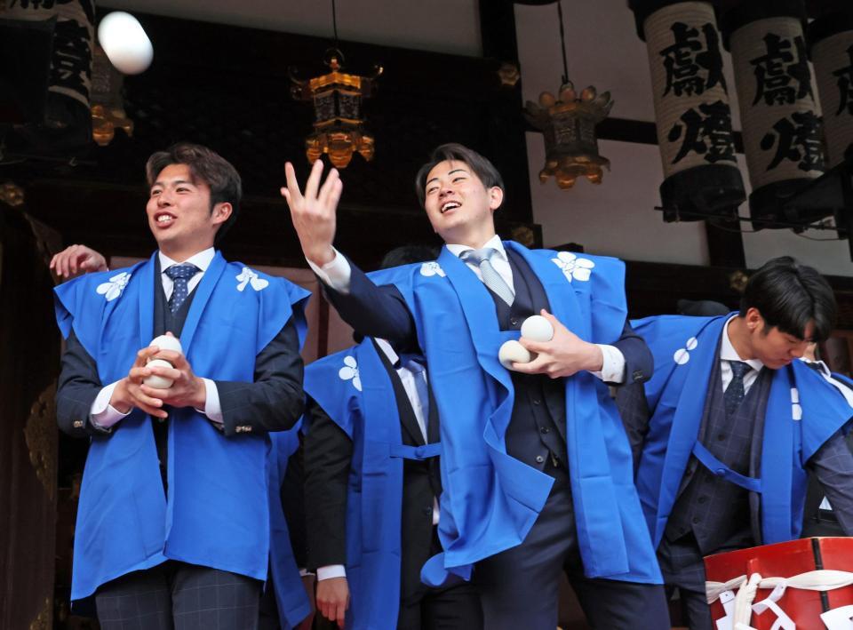 　初天神梅花祭に参加し、参拝者に福玉を投げ込む（左から）椎葉、下村（撮影・立川洋一郎）