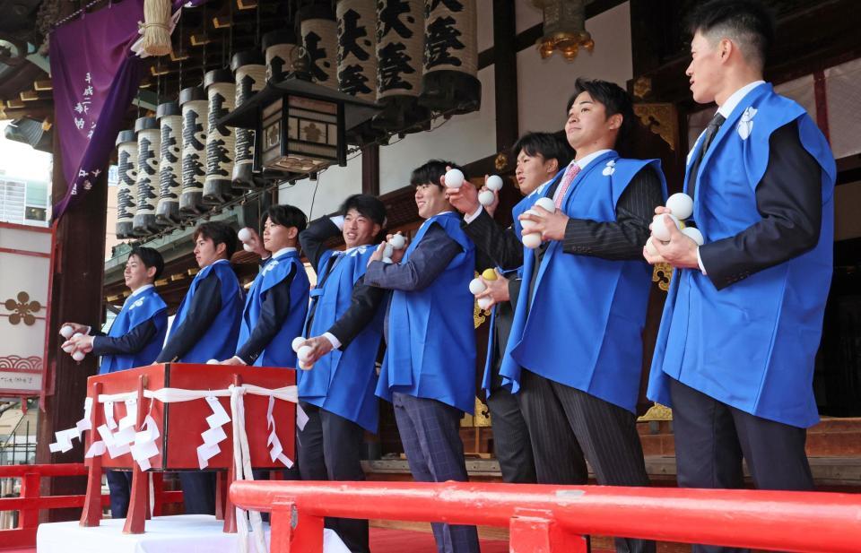 　初天神梅花祭に参加し、福玉を投げる（右から）福島、松原、津田、石黒、百崎、山田、椎葉、下村（撮影・立川洋一郎）