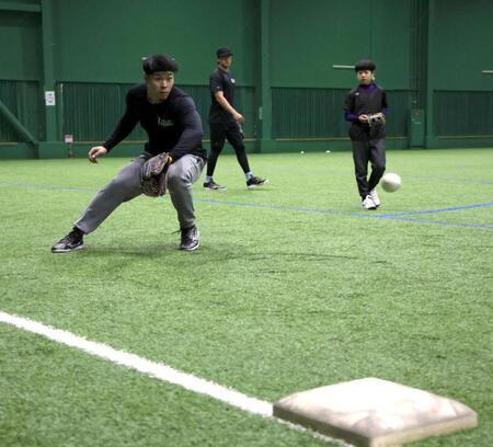　三塁のポジションでノックを受ける佐藤輝（左）＝撮影・北村雅宏
