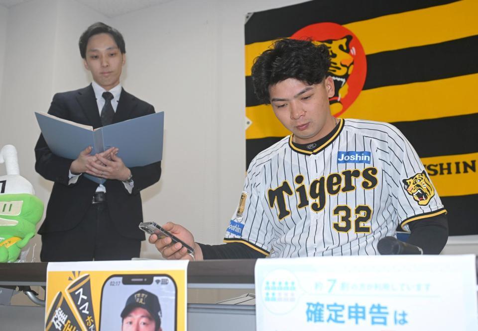 　確定申告の体験をする井上（右）＝撮影・石井剣太郎