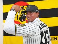 　入団会見を終えてユニホームに袖を通し、活躍を誓うアルナエス（撮影・立川洋一郎）