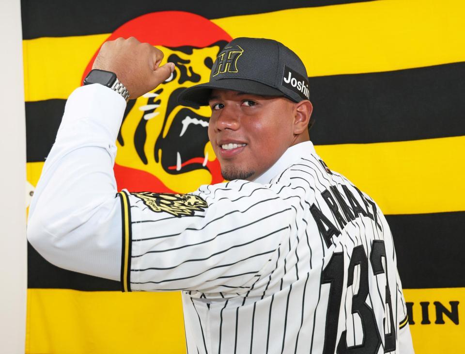 　入団会見を終えてユニホームに袖を通し、活躍を誓うアルナエス（撮影・立川洋一郎）