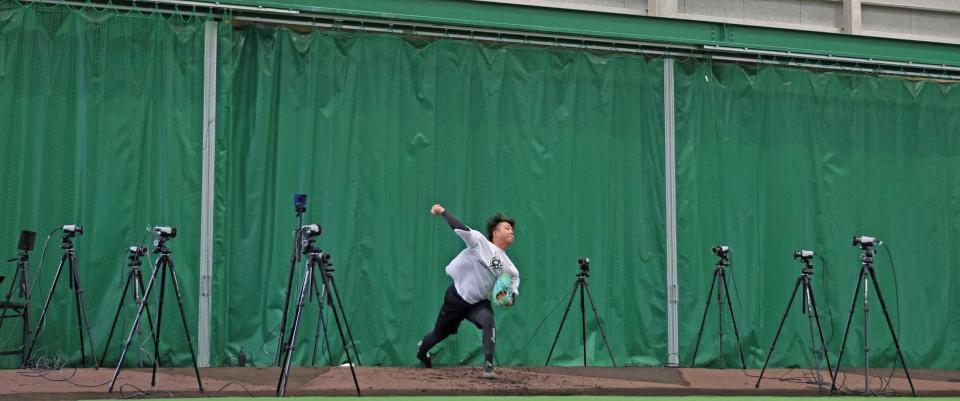 　マーカレス・モーションキャプチャーが設置される中、投球練習をする村上