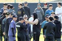 　誰ひとり半袖の選手がいない中、タンクトップ姿で自主トレに参加した佐藤輝（中央）（撮影・田中太一）