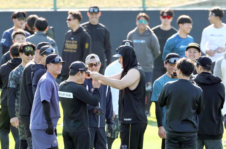 　誰ひとり半袖の選手がいない中、タンクトップ姿で自主トレに参加した佐藤輝（中央）（撮影・田中太一）
