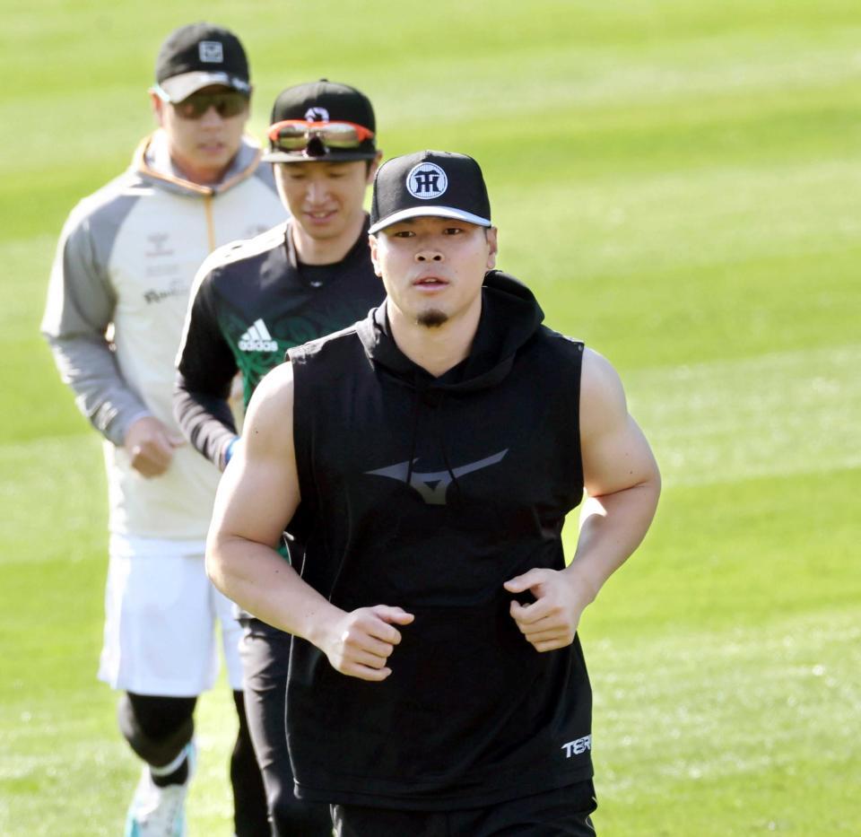 　二の腕を出してウオーミングアップをする佐藤輝（撮影・田中太一）