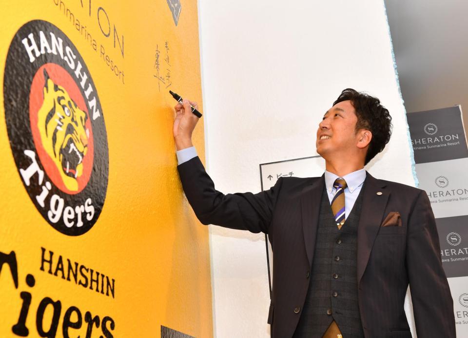 　チーム宿舎の壁にサインを入れる藤川監督（撮影・中田匡峻）