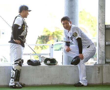 　ブルペンで投球練習を終えた岩崎（右）は藤田と言葉をかわす（撮影・山口登）