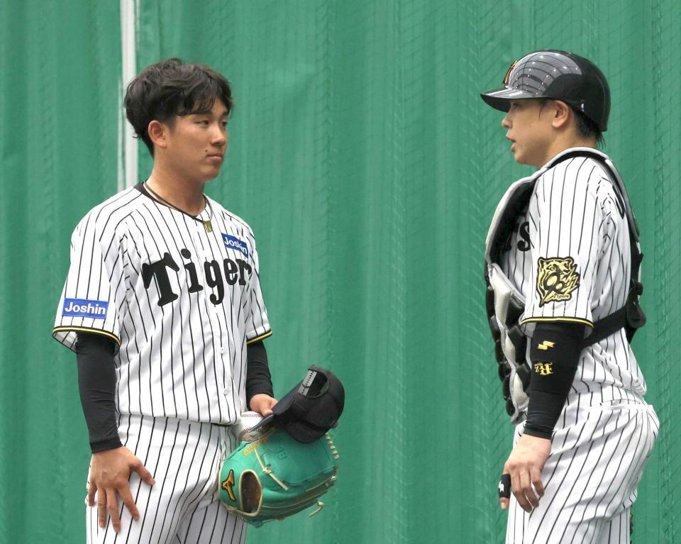 　ブルペンで梅野（右）と話す伊原