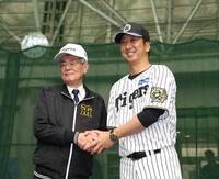 　秦オーナー（左）と握手を交わす藤川監督（撮影・中田匡峻）