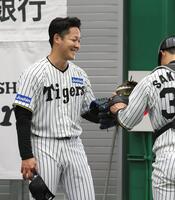 　ブルペンでの投球練習を終え、栄枝とグラブタッチを交わす木下（左）＝撮影・北村雅宏