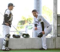 　ブルペンで投球練習を終えた岩崎（右）は藤田と言葉を交わす（撮影・山口登）