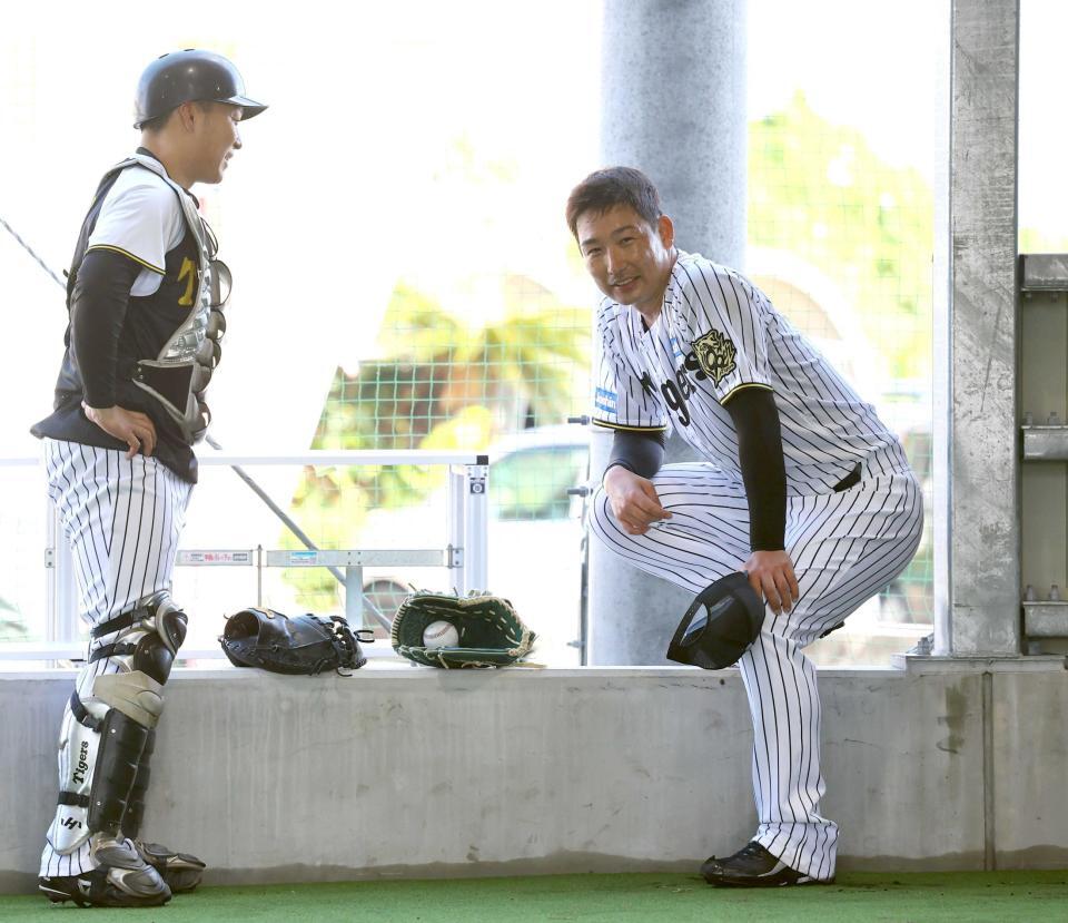 　ブルペンで投球練習を終えた岩崎（右）は藤田と言葉を交わす（撮影・山口登）