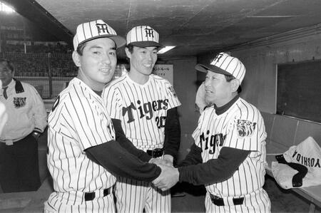 　本拠地初戦を飾り、伊藤（中央）、木戸（左）のバッテリーと握手する吉田監督＝８５年４月１６日
