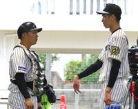 　ブルペンで投球練習を終えた今朝丸（右）は藤田と言葉を交わす（撮影・山口登）
