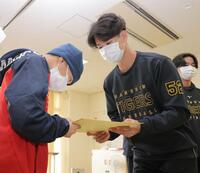 　子どもにプレゼントを渡す山田