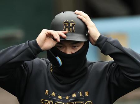 　あまりの気温の低さに、防寒しながらヘルメットをかぶる佐藤輝（撮影・田中太一）