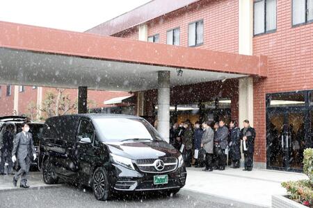 　雪が舞う中、葬儀場を出る吉田義男さんの棺を乗せた霊きゅう車（代表撮影）