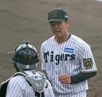 　１回を投げ終え、梅野（手前）と言葉を交わす門別（撮影・中田匡峻）