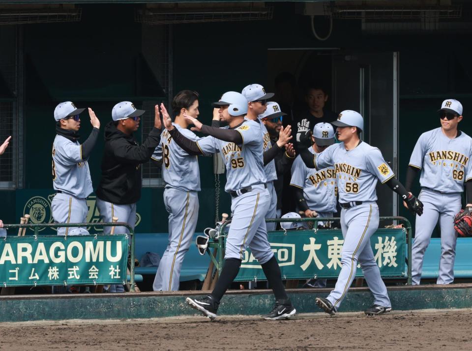 　３回、野口の２点適時打で生還し、ナインに迎えられるヘルナンデス（撮影・金田祐二）