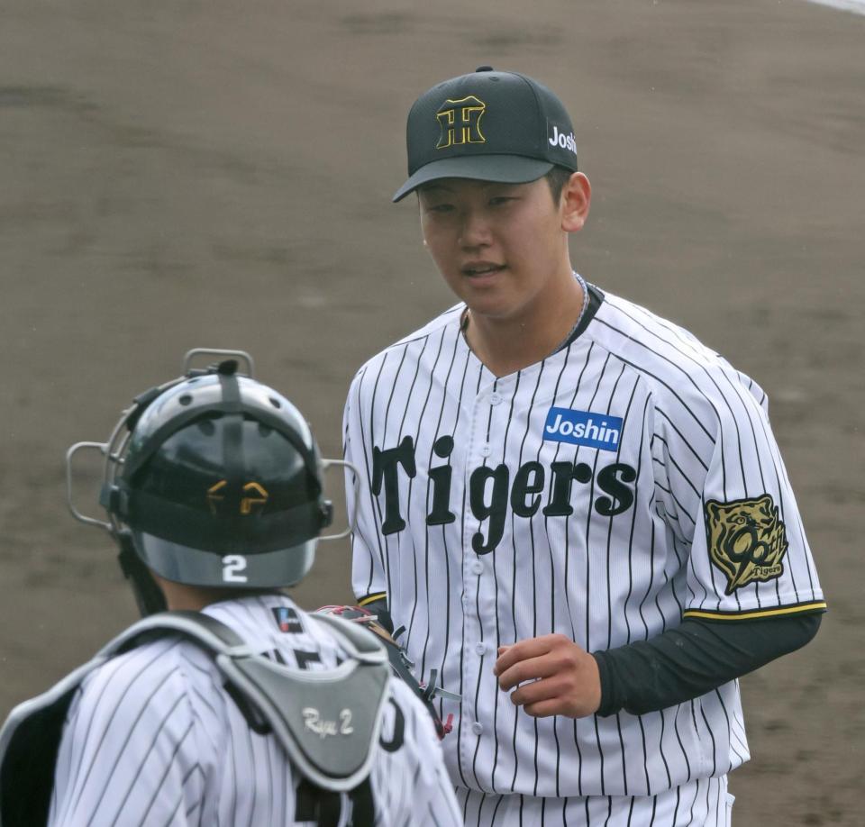 　１回を投げ終え、梅野（手前）と言葉を交わす門別（撮影・中田匡峻）