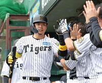 　１回、ライトに先制２ランを放ち、ナインとタッチを交わす佐藤輝（撮影・中田匡峻）