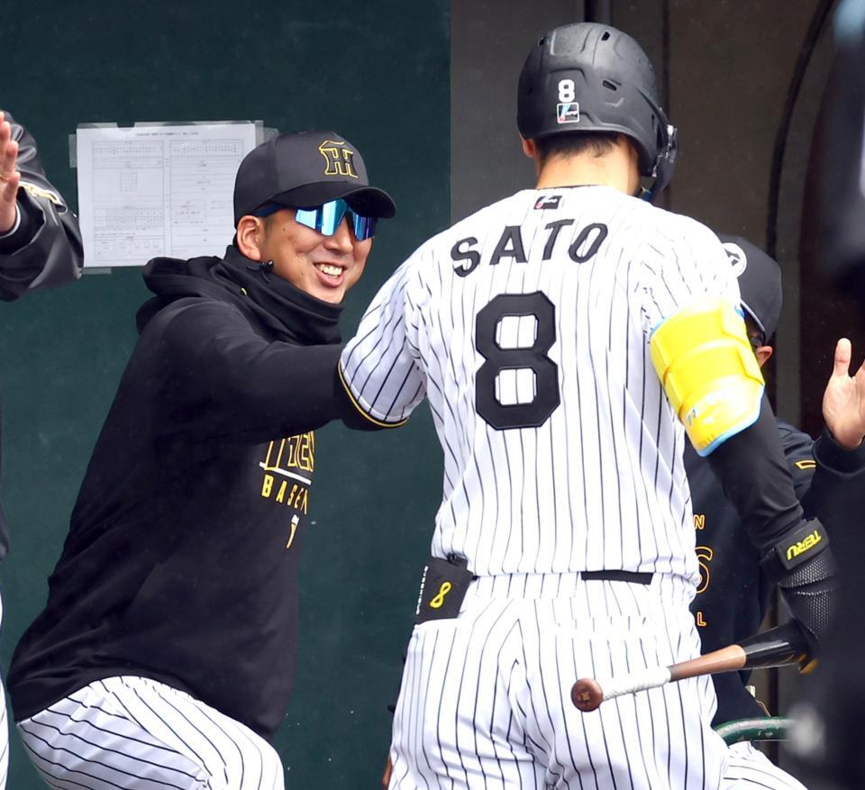 　１回、先制２ランを放った佐藤輝を笑顔で迎える藤川監督（左）＝撮影・山口登