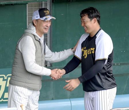 　午前の練習を終えた阪神・大山悠輔（右）と握手をしながら談笑する渡辺謙（撮影・田中太一）