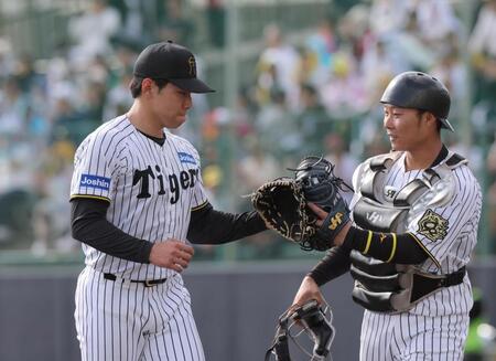 ８回の１イニングを無失点に抑えて阪神・藤田健斗（右）とグラブタッチを交わす阪神・工藤泰成＝宜野座（撮影・北村雅宏）