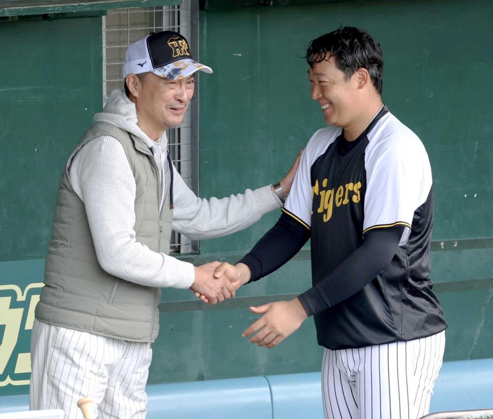 　午前の練習を終えた阪神・大山悠輔（右）と握手をしながら談笑する渡辺謙（撮影・田中太一）