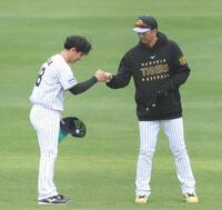 　シート打撃の登板を終えた伊原（左）は藤川監督とタッチを交わす（撮影・中田匡峻）