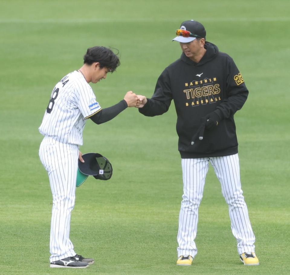 　シート打撃の登板を終えた伊原（左）は藤川監督とタッチを交わす（撮影・中田匡峻）