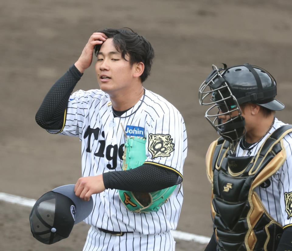 　シート打撃での登板を終え、梅野（右）の話に耳を傾ける伊原（撮影・中田匡峻）