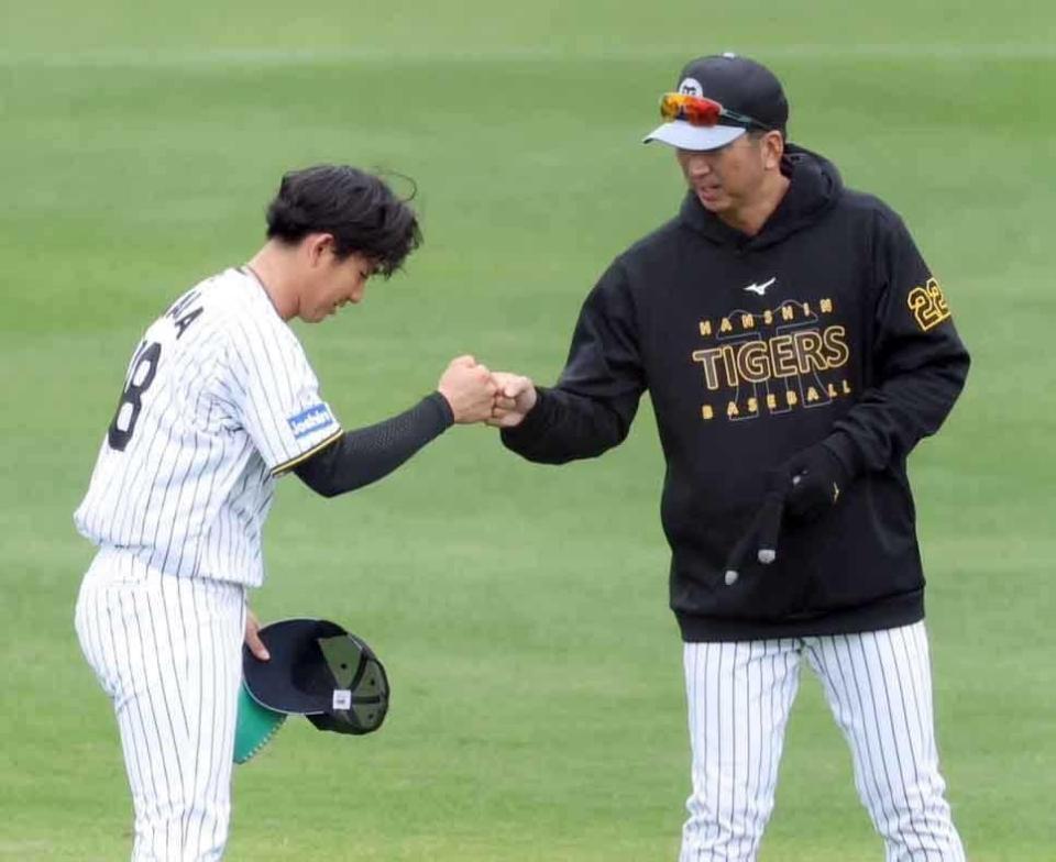 　登板後に藤川監督（右）とグータッチを交わす伊原