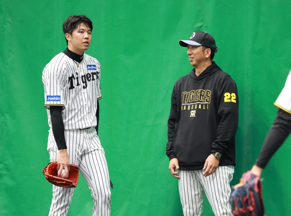 　ブルペン投球を終えた才木と話す藤川監督＝１３日