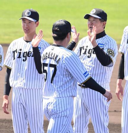 　具志川キャンプを打ち上げ、ナインとタッチする山田（左）と平田２軍監督（右）＝撮影・西田忠信