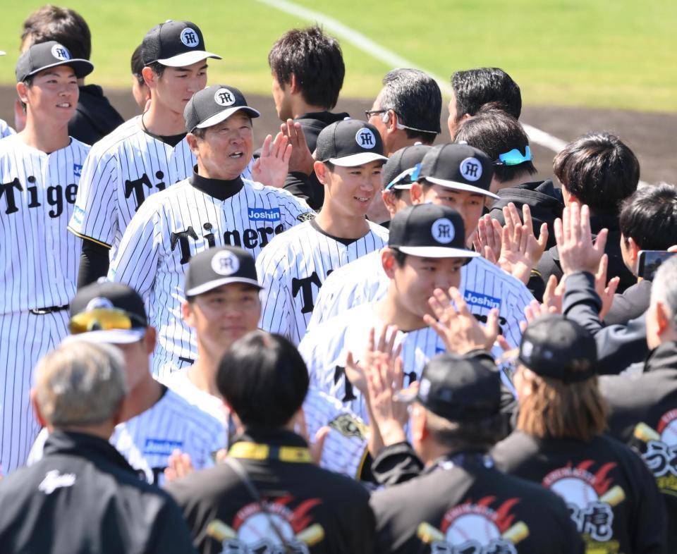 　具志川キャンプを打ち上げ、スタッフらと笑顔でタッチする平田２軍監督（左から３人目）＝撮影・西田忠信