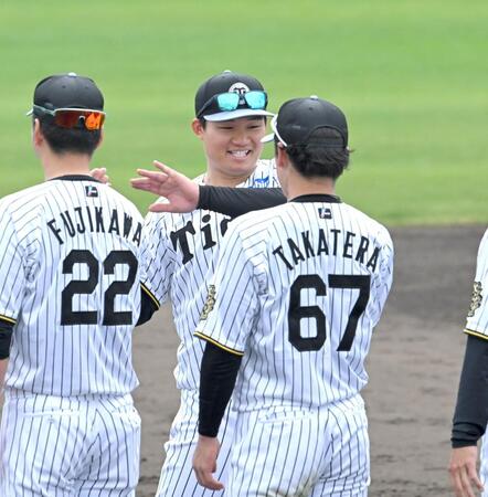 　充実のキャンプを打ち上げ、藤川監督（２２）らと笑顔でタッチを交わす森下（撮影・飯室逸平）