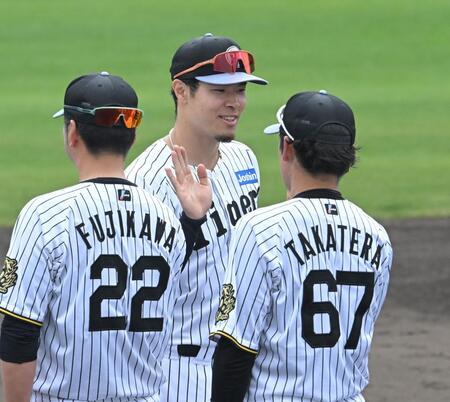 　充実のキャンプを終え、藤川監督（２２）と笑顔でタッチを交わす佐藤輝（撮影・飯室逸平）