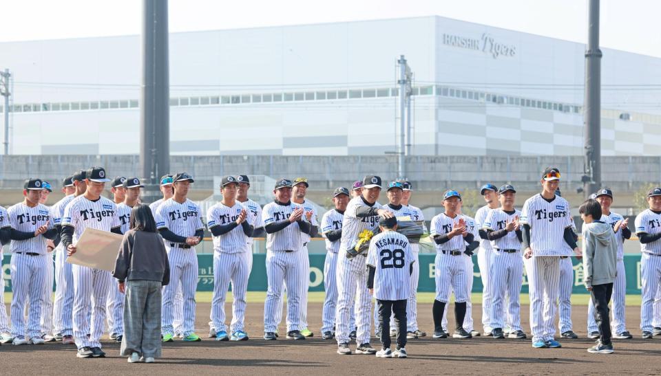 　尼崎市の歓迎セレモニーで花束を受け取る平田２軍監督（中央）＝撮影・立川洋一郎
